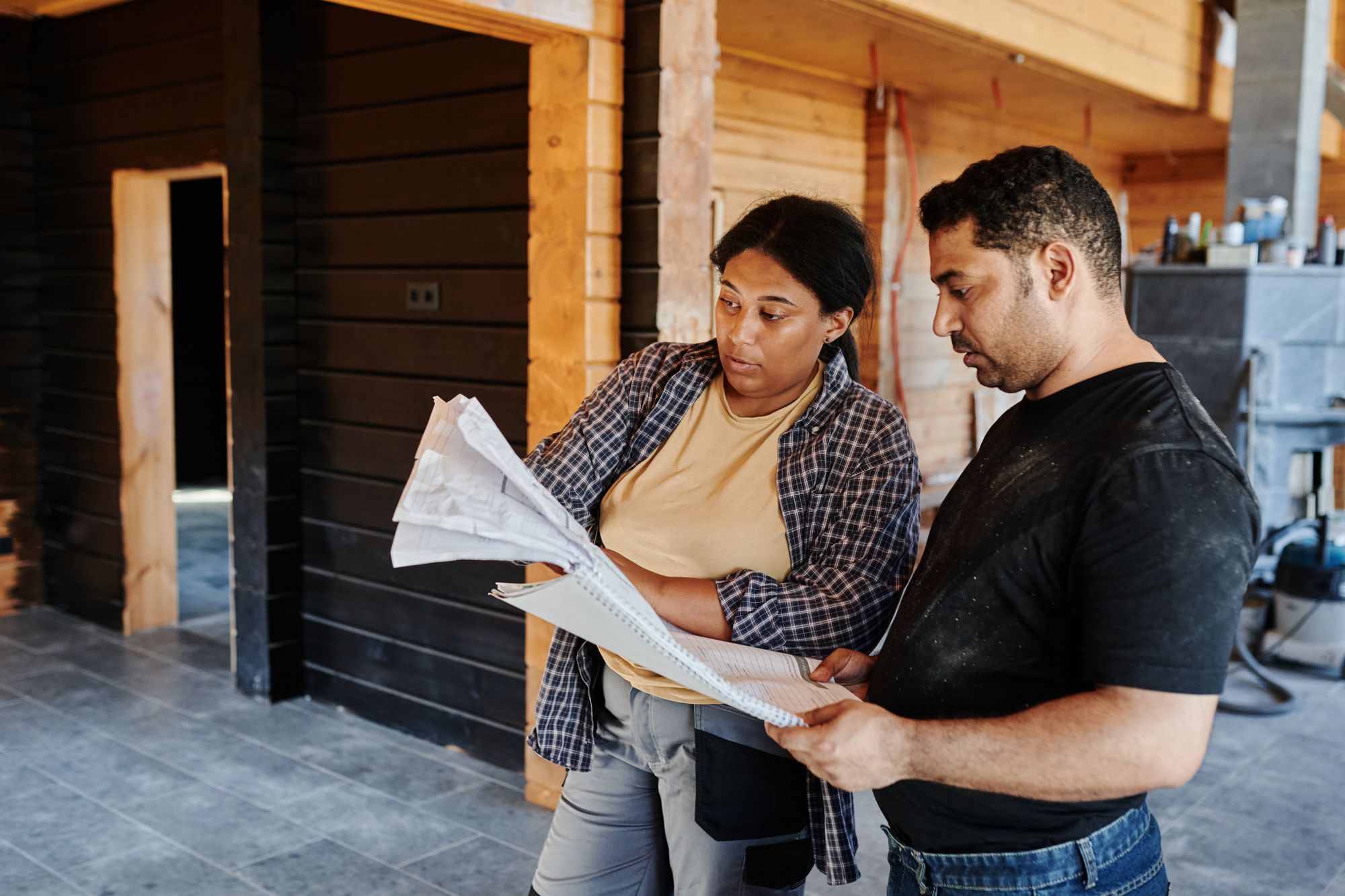 Construction colleagues reviewing plans at a building site